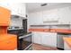 Clean kitchen with stainless steel appliances, white cabinetry, and wood-look flooring at 211 W Valencia St, Lakeland, FL 33805