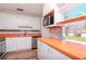 White and bright eat-in kitchen features stainless steel appliances, white cabinets, and an abundance of natural light at 211 W Valencia St, Lakeland, FL 33805