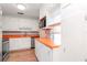 Kitchen showcasing white cabinets, a stainless steel dishwasher, and wood-look flooring at 211 W Valencia St, Lakeland, FL 33805