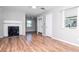 Bright living room with wood floors, a fireplace, ceiling fan, and natural light at 211 W Valencia St, Lakeland, FL 33805