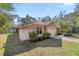 Exterior side of the garage featuring well-manicured landscaping and a driveway at 7641 Sw 185Th Cir, Dunnellon, FL 34432