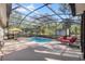 Relaxing screened-in pool area featuring lounge chairs and shade umbrellas at 7641 Sw 185Th Cir, Dunnellon, FL 34432