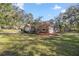 Well-maintained side exterior of the home with a lush green lawn and mature trees at 7641 Sw 185Th Cir, Dunnellon, FL 34432