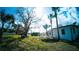 Spacious backyard showing lush green grass, mature trees, and a view of the white home's exterior at 1401 Josephine St, Lakeland, FL 33815