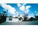 Bright white single-story home with well-manicured lawn and concrete driveway against a blue sky at 1401 Josephine St, Lakeland, FL 33815