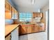 Bright kitchen with wooden cabinets, white appliances, and a large window above the sink at 305 Bearcreek Dr, Bartow, FL 33830