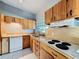 Kitchen boasting a large sink, white appliances, wooden cabinets, and white tile flooring at 305 Bearcreek Dr, Bartow, FL 33830