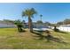 Backyard boasts a well-manicured lawn, pool, privacy fence, and tropical landscaping at 17 Se 61St Ct, Ocala, FL 34472