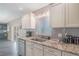 A bright kitchen with white cabinetry, granite countertops, and stainless steel appliances at 17 Se 61St Ct, Ocala, FL 34472