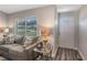 Cozy living room with couch, lamps, a window, and a white front door with decorative half-moon window at 17 Se 61St Ct, Ocala, FL 34472