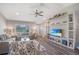 Comfortable living room features a large sectional sofa, wood flooring, and custom shelving with a flatscreen TV at 17 Se 61St Ct, Ocala, FL 34472