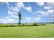 Expansive backyard view overlooking a calm lake, lush greenery, and a beautiful blue sky at 2500 21St Nw St # 88, Winter Haven, FL 33881