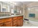 A spacious bathroom with a double vanity featuring granite counters, plenty of storage, and a tiled shower at 2500 21St Nw St # 88, Winter Haven, FL 33881
