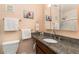 Well lit bathroom featuring granite counters, an oval sink, and a shower with sliding glass doors at 2500 21St Nw St # 88, Winter Haven, FL 33881