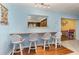 Kitchen bar area with four seats open to a room with blue walls at 2500 21St Nw St # 88, Winter Haven, FL 33881