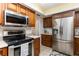 The kitchen features stainless steel appliances, wooden cabinets, and tile floors at 2500 21St Nw St # 88, Winter Haven, FL 33881