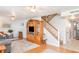 Light-filled living room with beautiful wood floors and staircase, and an entertainment center at 2500 21St Nw St # 88, Winter Haven, FL 33881
