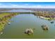 Aerial view of a real estate lot, with a lake and neighborhoods in the distance under a sunny sky at 2569 Rogers Rd, Lakeland, FL 33812