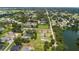 Overhead perspective of neighborhood, lush trees, and community near a tranquil lake at 2569 Rogers Rd, Lakeland, FL 33812