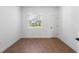 Inviting bedroom with wood-look tile flooring, featuring a window and a modern white door at 2569 Rogers Rd, Lakeland, FL 33812