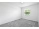 Sunlit bedroom featuring neutral carpeting, a bright window, and a clean, minimalist design at 2569 Rogers Rd, Lakeland, FL 33812