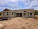An unfinished concrete block home with a brown roof sits on a sunny lot waiting to be completed at 2569 Rogers Rd, Lakeland, FL 33812