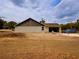 An unfinished concrete block home is shown with siding above the garage wall on a sunny lot at 2569 Rogers Rd, Lakeland, FL 33812