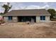 An unfinished concrete block home has blue coverings over the windows and doors on a sunny lot at 2569 Rogers Rd, Lakeland, FL 33812