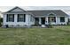 Charming single-story home with white siding, black shutters, and a well-manicured front lawn at 2569 Rogers Rd, Lakeland, FL 33812