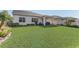 Expansive backyard featuring lush lawn, a covered patio, and tropical landscaping, perfect for outdoor living at 5618 Winterbrook Way, Winter Park, FL 32792