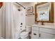 Well-lit bathroom featuring a shower-tub combo, a vanity with storage, and a decorative wood-framed mirror at 5618 Winterbrook Way, Winter Park, FL 32792