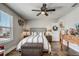 Comfortable bedroom with a tufted headboard, wood floors, ceiling fan, and a decorative wreath on the door at 5618 Winterbrook Way, Winter Park, FL 32792