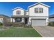 Charming two-story home featuring a well-manicured lawn, gray trim, and a welcoming two-car garage at 5618 Winterbrook Way, Winter Park, FL 32792
