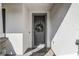 Front entryway featuring a gray front door adorned with a decorative wreath and white stucco walls at 5618 Winterbrook Way, Winter Park, FL 32792