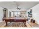 Open game room features a pool table, accent rug, fireplace and television on shiplap wall at 5618 Winterbrook Way, Winter Park, FL 32792