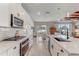 A bright, open kitchen with white cabinetry and stainless steel appliances, with dining area beyond at 5618 Winterbrook Way, Winter Park, FL 32792