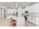 Full view of kitchen with stainless steel appliances, white cabinets, center island, and wooden-look tile floors at 5618 Winterbrook Way, Winter Park, FL 32792