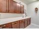 Laundry room with wood cabinets, a white countertop, and neutral walls at 5618 Winterbrook Way, Winter Park, FL 32792