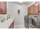 Functional laundry room with modern washer and dryer, ample cabinet space, and a sink with a modern faucet at 5618 Winterbrook Way, Winter Park, FL 32792