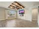 Living room with ceiling beams, a fireplace, and a large window, with modern wood look flooring at 5618 Winterbrook Way, Winter Park, FL 32792