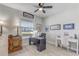 Comfortable office space with a ceiling fan, large window, sleek desk, and a variety of decorative items at 5618 Winterbrook Way, Winter Park, FL 32792