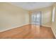 Bright, vacant bedroom with hardwood floors, ceiling fan, and sliding glass doors to a screened-in porch at 21505 Castle View Ct, Leesburg, FL 34748