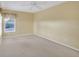 Spacious bedroom featuring neutral carpet, ceiling fan, and window to bring in natural light at 21505 Castle View Ct, Leesburg, FL 34748