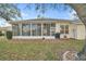 Back of home showing enclosed patio, large windows, and neat landscaping for outdoor enjoyment at 21505 Castle View Ct, Leesburg, FL 34748