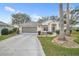 Charming one-story home with a well-maintained lawn, mature trees, and an attached two-car garage at 21505 Castle View Ct, Leesburg, FL 34748