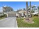 Inviting one-story home with a well-manicured lawn, mature trees, and an attached two-car garage at 21505 Castle View Ct, Leesburg, FL 34748