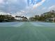 An inviting view of the community tennis courts, featuring well-maintained blue courts amid a lush, tree-lined setting at 21505 Castle View Ct, Leesburg, FL 34748