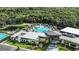 Aerial view of community clubhouse, pool, and surrounding landscape with lush greenery at 2611 Skyline Loop, Kissimmee, FL 34758