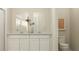 Well-lit bathroom featuring a double vanity, modern faucet fixtures, and a framed mirror at 2611 Skyline Loop, Kissimmee, FL 34758