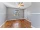 Charming bedroom featuring a ceiling fan, hardwood floors, and a window letting in natural light at 2730 Woodland Hills Ave, Lakeland, FL 33803